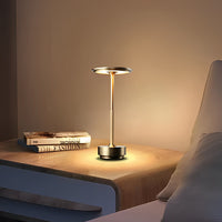 Lampe de table dorée et allumée dans la chambre à coucher