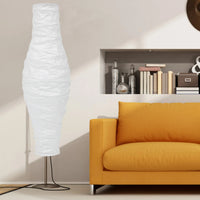 Abat Jour Lampadaire Vertical de Style Nordique en Papier sur fond blanc avec un canapé orange à droite et des livres en fond