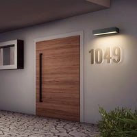 Applique Murale LED de Style Moderne en Aluminium sur un mur gris avec une porte à gauche et un numéro 1049 inscrit en dessous