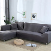 Housse Canapé d'Angle Extensible Grise et Moderne en Polyester sur fond gris avec des tableaux