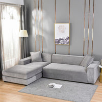 Housse Canapé d'Angle Moderne en Peluche de Velours sur fond gris avec un tableau et un tapis gris