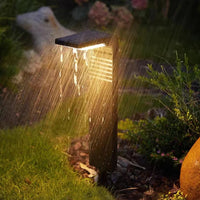 Lampadaire Extérieur Solaire LED Noir et Étanche sous la pluie dans un jardin