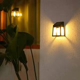 Lampe Murale Extérieure à Énergie Solaire de Style Lanterne allumée sur un mur extérieur la nuit