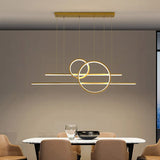 Lampe Suspendue Dorée de Style Moderne à Intensité Variable sur fond beige avec une table et des chaises
