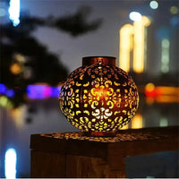 Lanterne Extérieure Solaire LED de Style Antique en Cuivre posée sur un rebord sur fond flouté la nuit