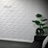 Panneau Mural 3D Blanc à Motif de Vagues en Plastique sur un mur avec une plante à droite