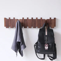 Porte-Manteau Bois Design avec Crochets Rabattables installé sur un mur gris avec une serviette et un sac suspendu dessus