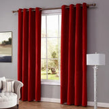 Rideaux Occultants Rouges et Longs devant une fenêtre dans une pièce avec un fauteuil à gauche et une lampe à droite