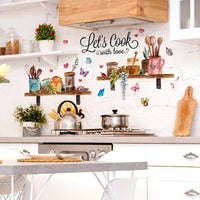 Sticker Cuisine en Forme d'Étagères avec des Ustensiles et des Papillons collé sur le mur d'une cuisine avec une plaque de cuisson une étagère des pots de fleurs et une table devant