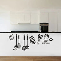 Sticker Cuisine avec des Ustensiles et Inscription Happy Kitchen collé sur le mur d'une cuisine avec un évier et des placards au dessus