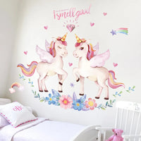 Sticker Mural Chambre avec des Licornes des Fleurs et des Cœurs collé sur un mur avec un lit un coussin et une chaise devant