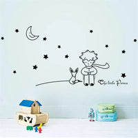 Sticker Mural Chambre avec un Petit Prince et un Renard sous la Lune avec des Étoiles collé sur un mur bleu avec des jouets pour enfant devant