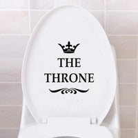 Sticker Mural Salle de Bain avec une Couronne et l'Inscription The Throne collé sur la cuvette des toilettes avec un mur en carrelage derrière