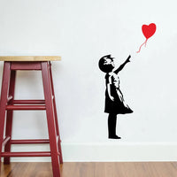 Sticker Mural Salon avec une Petite Fille et un Ballon en Forme de Coeur collé sur un mur blanc avec un tabouret à gauche